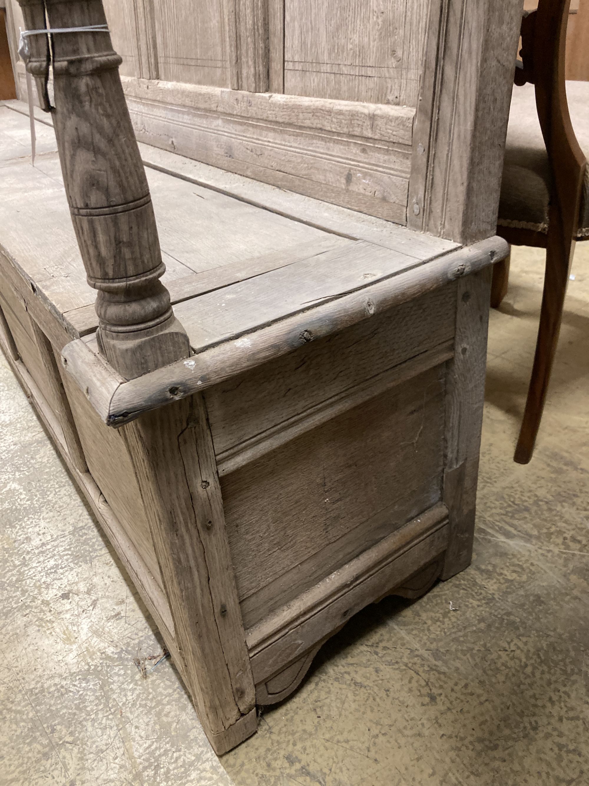 An 18th century bleached oak panelled box seat settle, length 206cm, depth 41cm, height 145cm